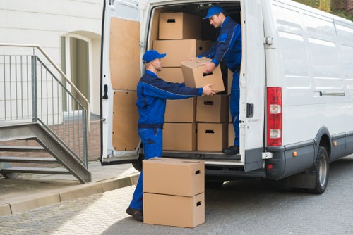 Removal staff moving office equipment carefully through a building